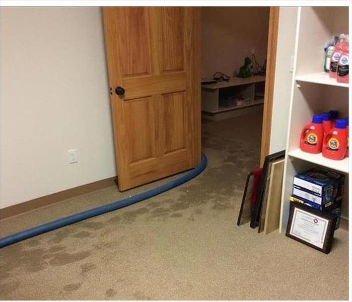 water soaked brown carpet, goods stored on white shelving