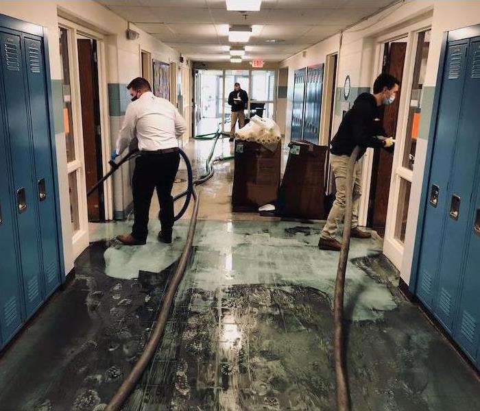 SERVPRO techs with extraction equipment in school hallway